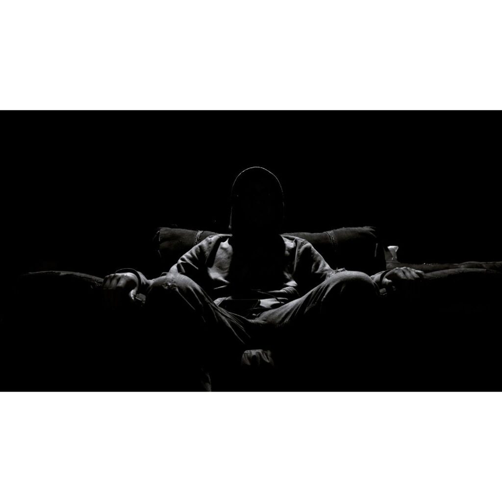 Hombre sentado con luz dura cenital